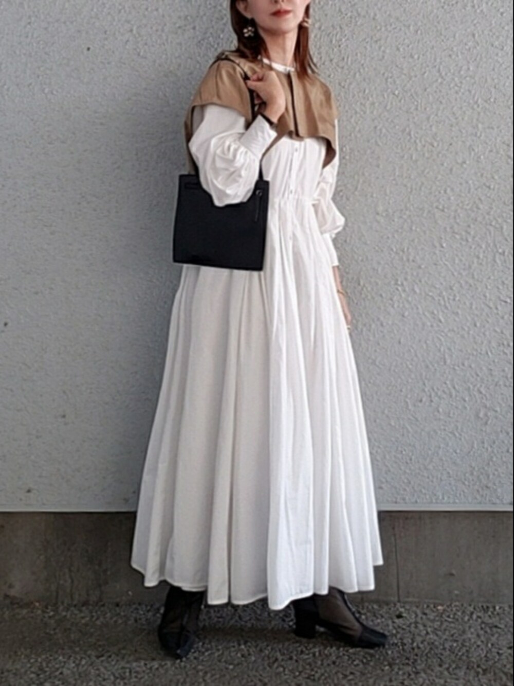 ホワイト系のシャツワンピース、ブラック系のトートバッグ、ブラック系のブーツを着用したレディースの秋コーディネートの2枚目の写真