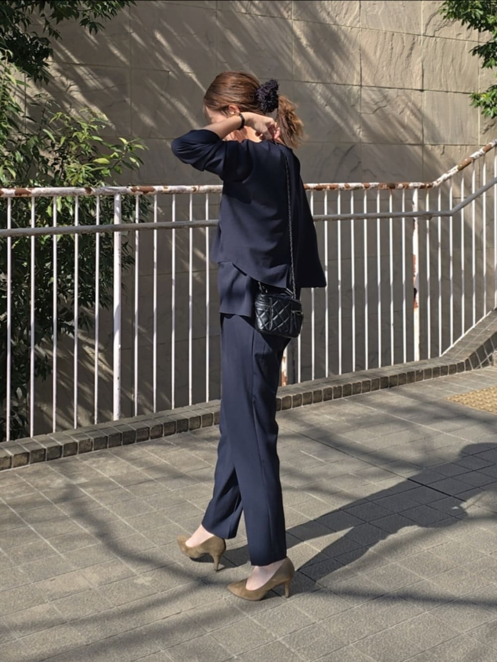 ブラック系のスーツセットを着用したレディースの春コーディネートの3枚目の写真