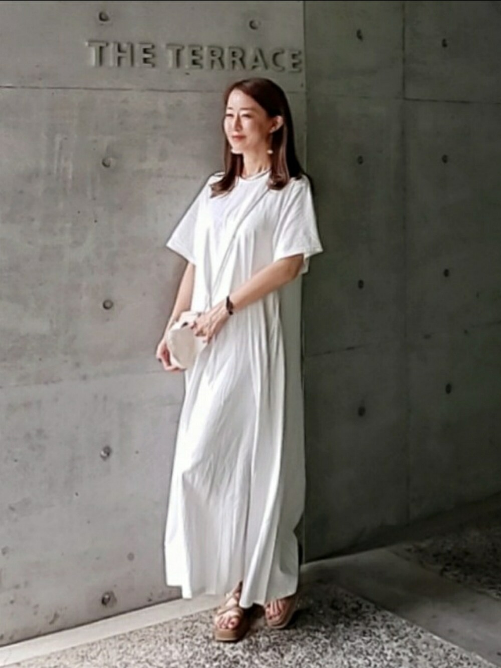 ホワイト系のワンピース、ホワイト系のショルダーバッグ、ブラウン系のサンダルを着用したレディースの夏コーディネートの4枚目の写真