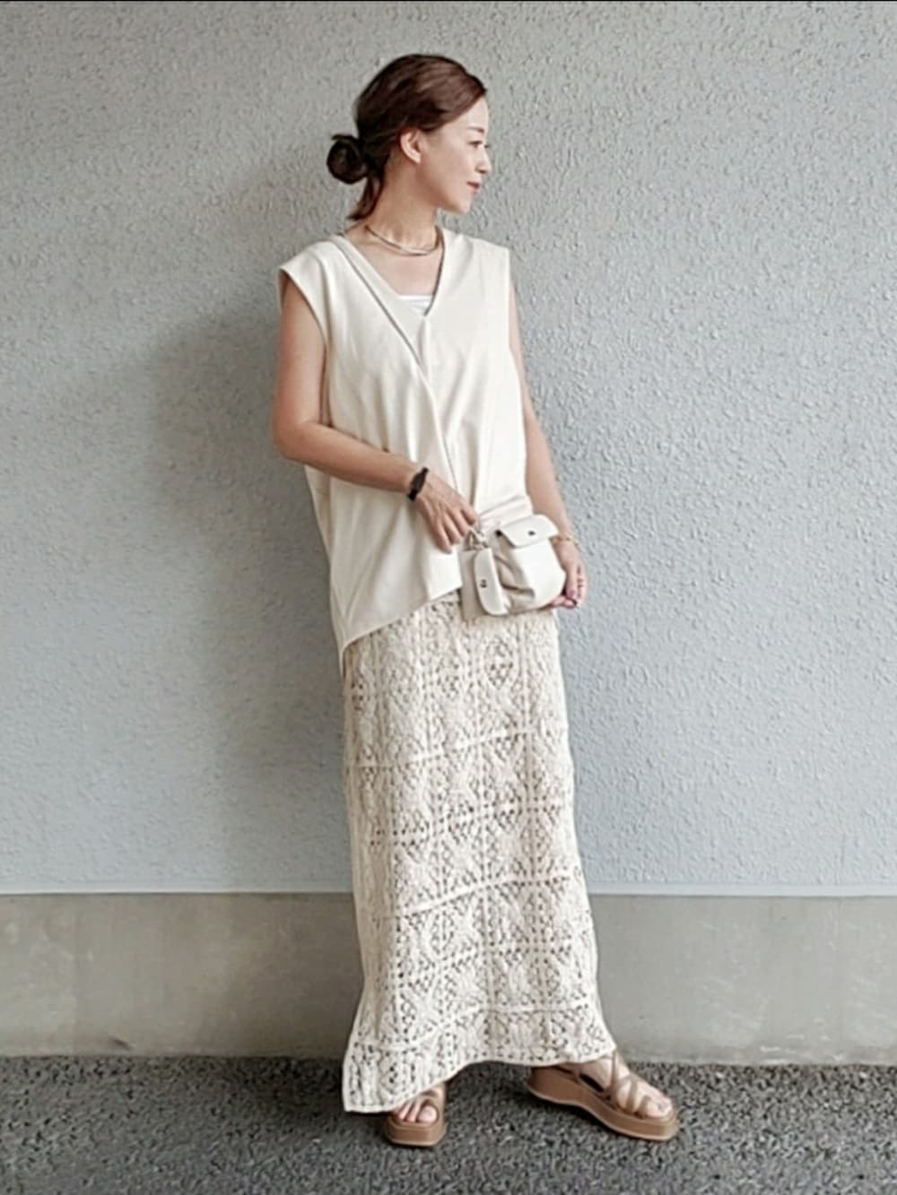 ホワイト系のワンピース/ドレス、ホワイト系のショルダーバッグ、ブラウン系のサンダルを着用したレディースの夏コーディネートの2枚目の写真