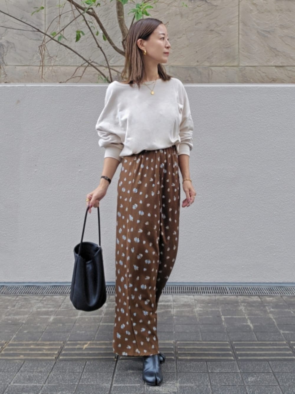 ホワイト系のスウェット、ブラウン系のスカートを着用したレディースの秋コーディネートの2枚目の写真