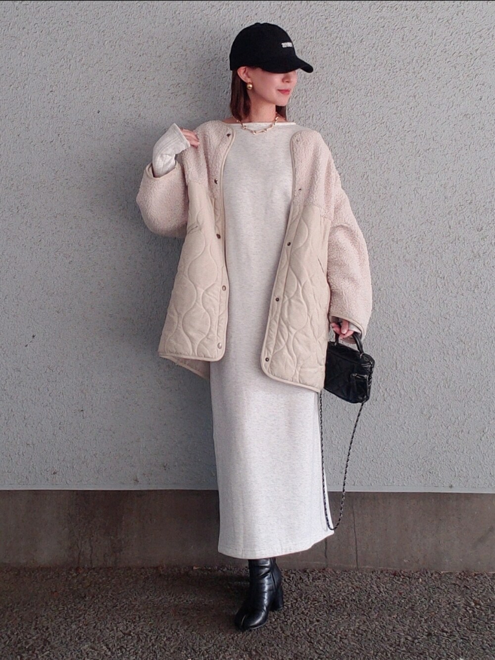 ベージュ系のワンピース、ホワイト系のブルゾン、ブラック系のブーツを着用したレディースの冬コーディネートの4枚目の写真