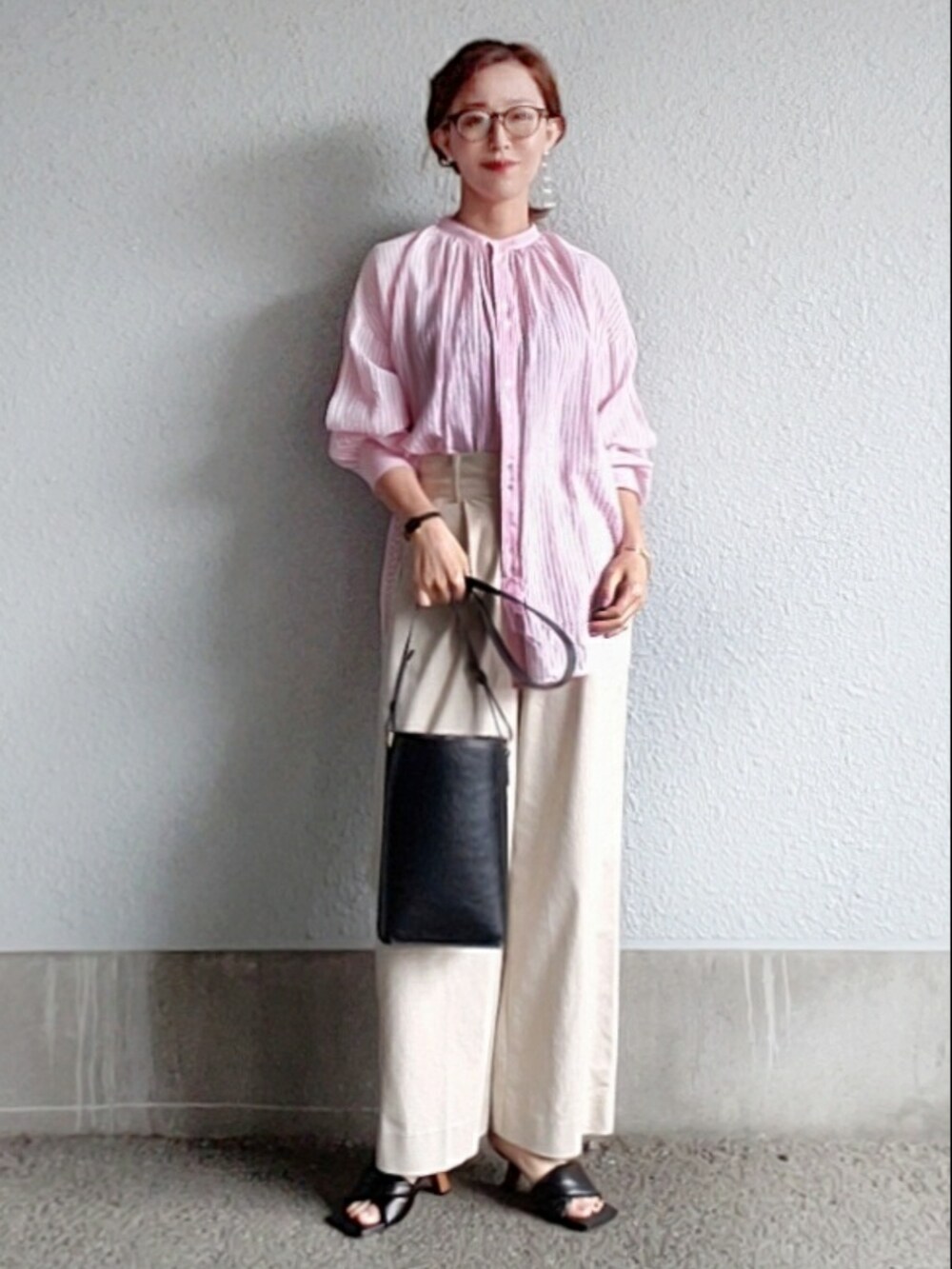 ブラック系のサンダル、ピンク系のシャツ/ブラウス、ブラック系のバッグを着用したレディースの春コーディネートの2枚目の写真