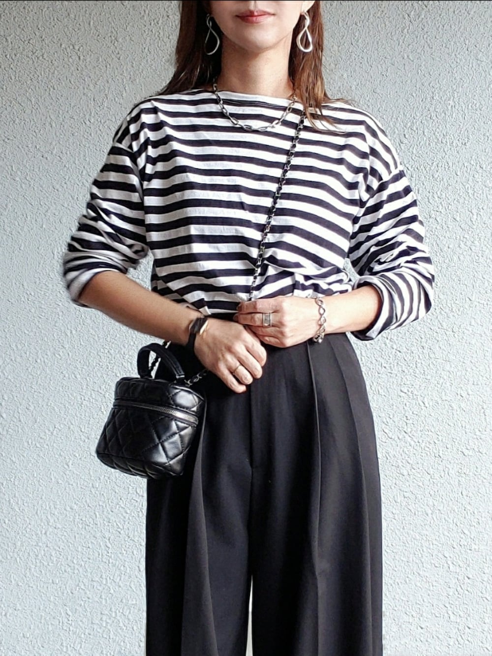 ブラック系のスラックス、ブラック系のTシャツ/カットソー、ブラック系のブーツを着用したレディースの秋コーディネートの2枚目の写真