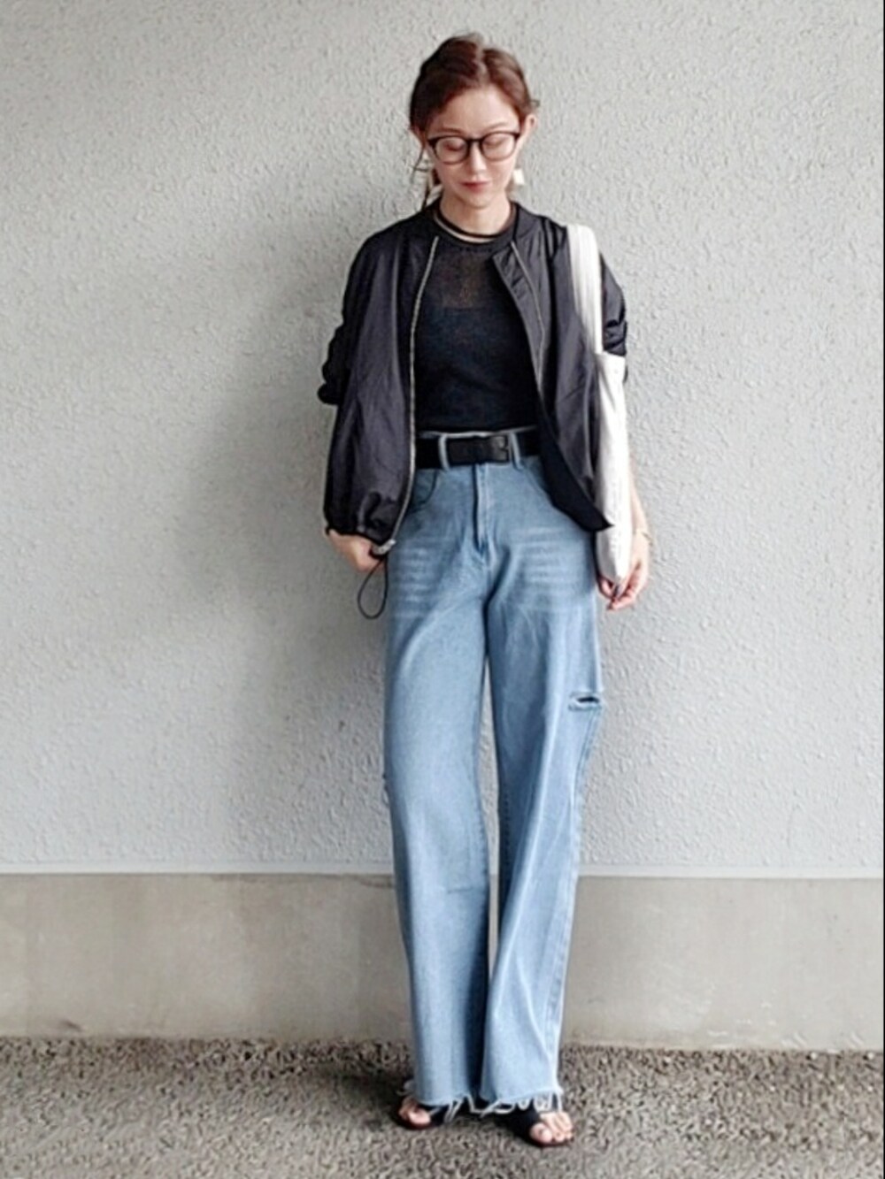 グレー系のニット/セーター、ブルー系のデニムパンツ、ブラック系のサンダルを着用したレディースの春コーディネートの3枚目の写真