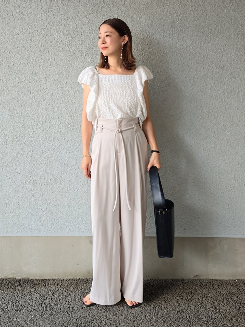 ホワイト系のシャツ/ブラウス、ホワイト系のその他パンツ、ブラック系のサンダルを着用したレディースの夏コーディネートの3枚目の写真