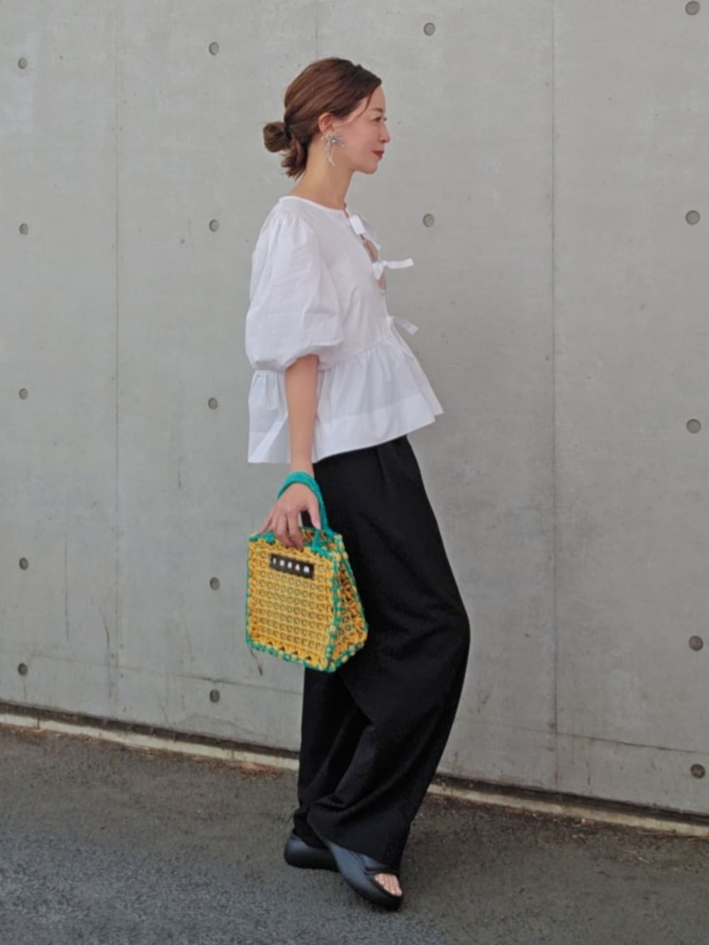 ホワイト系のシャツ/ブラウス、ブラック系のスラックス、ブラック系のシューズを着用したレディースの春コーディネートの2枚目の写真