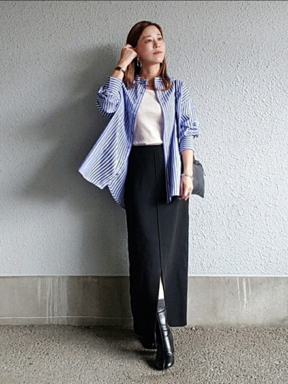 ブルー系のシャツ/ブラウス、ブラック系のスカート、ブラック系のブーツを着用したレディースの秋コーディネートの5枚目の写真