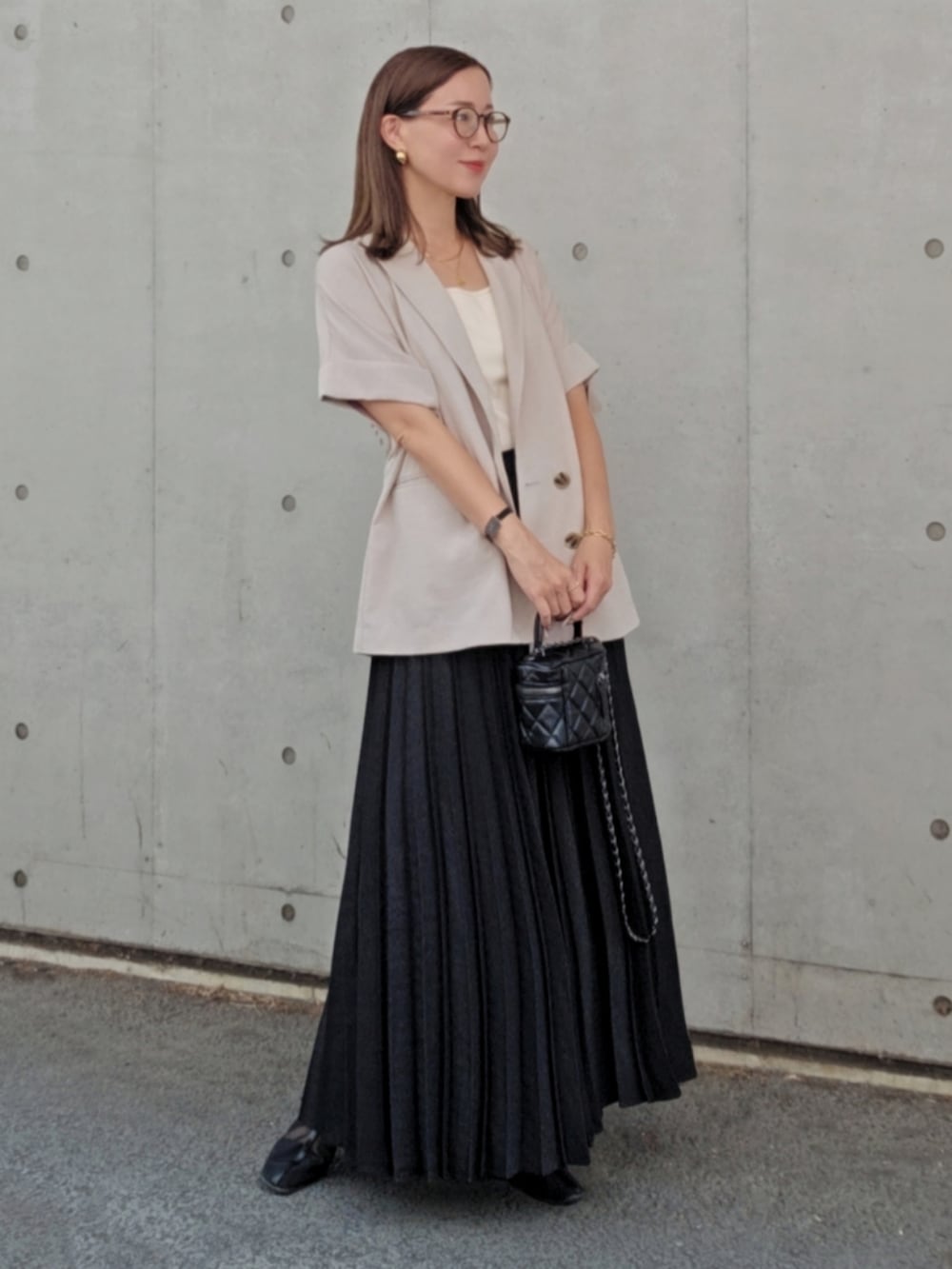 ブラック系のスカート、グレー系のシャツ/ブラウス、ブラック系のバッグを着用したレディースの夏コーディネートの2枚目の写真