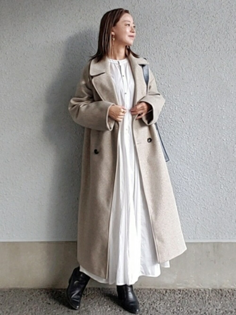 ベージュ系のジャケット/アウター、ホワイト系のシャツワンピース、ブラック系のブーツを着用したレディースの秋コーディネートの2枚目の写真