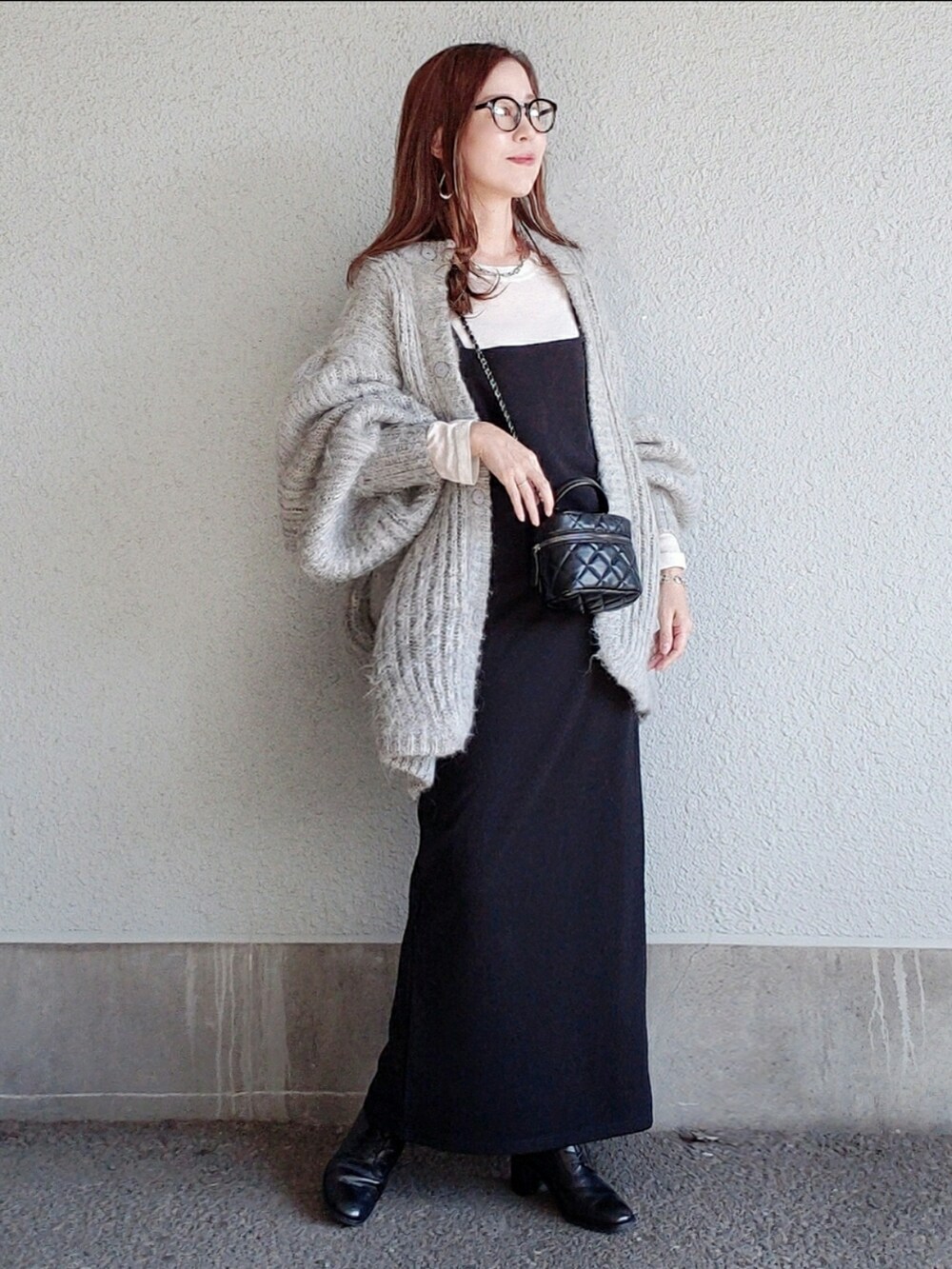 グレー系のカーディガン/ボレロ、ブラック系のワンピース、ブラック系のブーツを着用したレディースの秋コーディネートの4枚目の写真