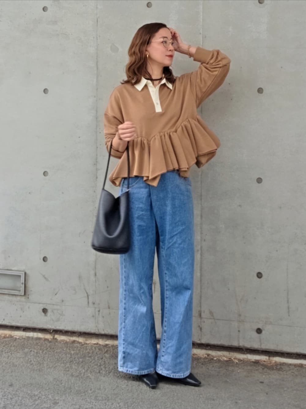 イエロー系のスウェット、ブルー系のデニムパンツ、ブラック系のパンプスを着用したレディースの春コーディネートの3枚目の写真