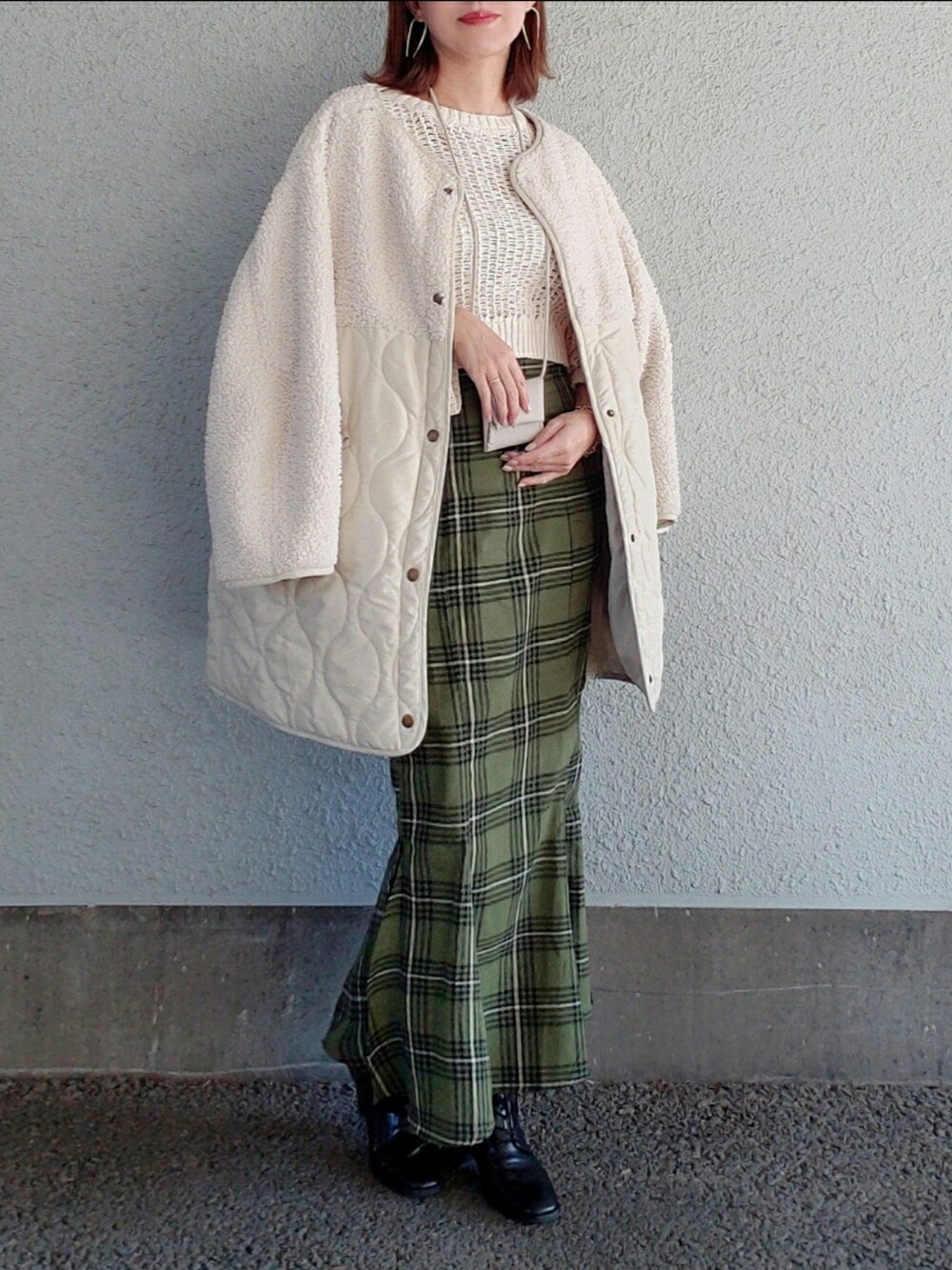 ホワイト系のニット/セーター、グリーン系のスカート、ブラック系のブーツを着用したレディースの冬コーディネートの4枚目の写真