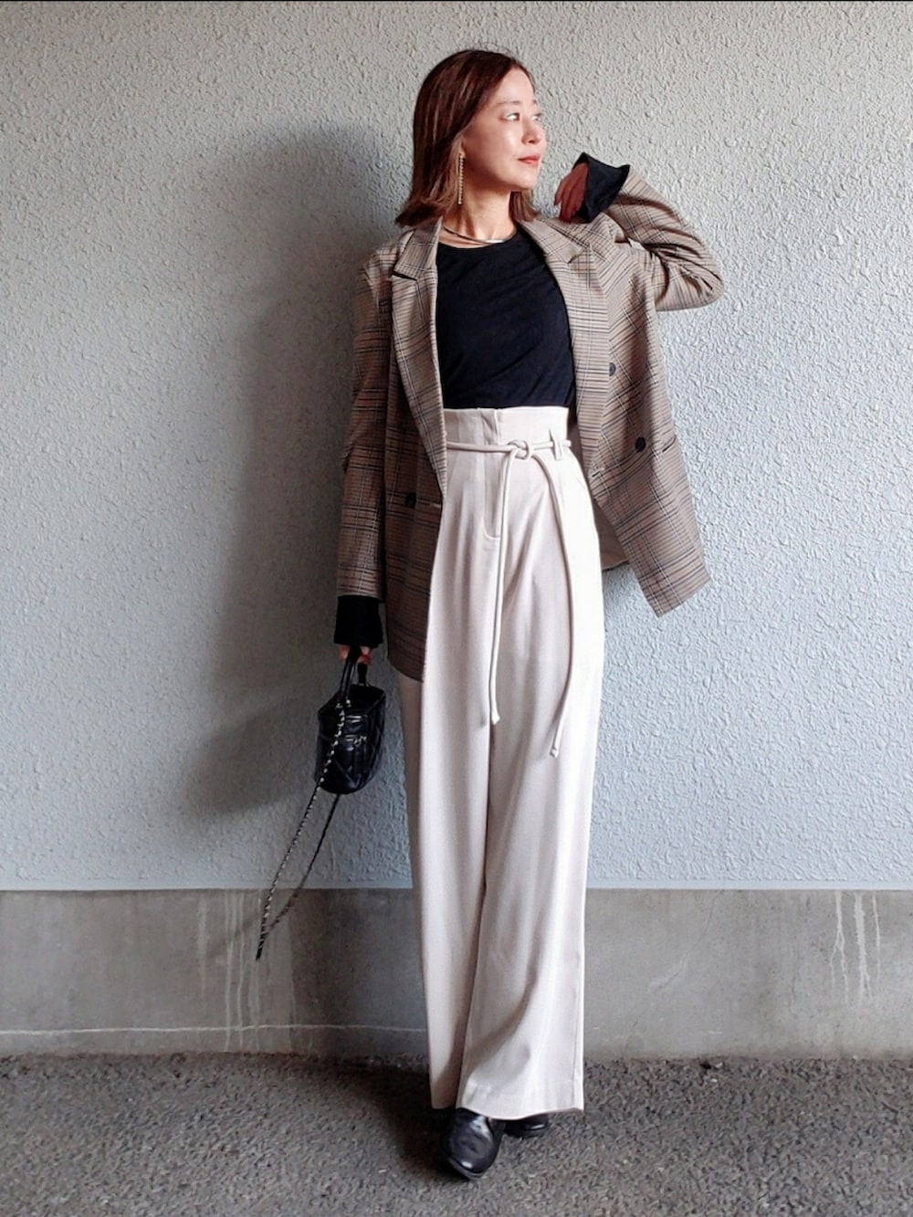 ホワイト系のその他パンツ、ブラック系のブーツ、ブラック系のバッグを着用したレディースの冬コーディネートの2枚目の写真