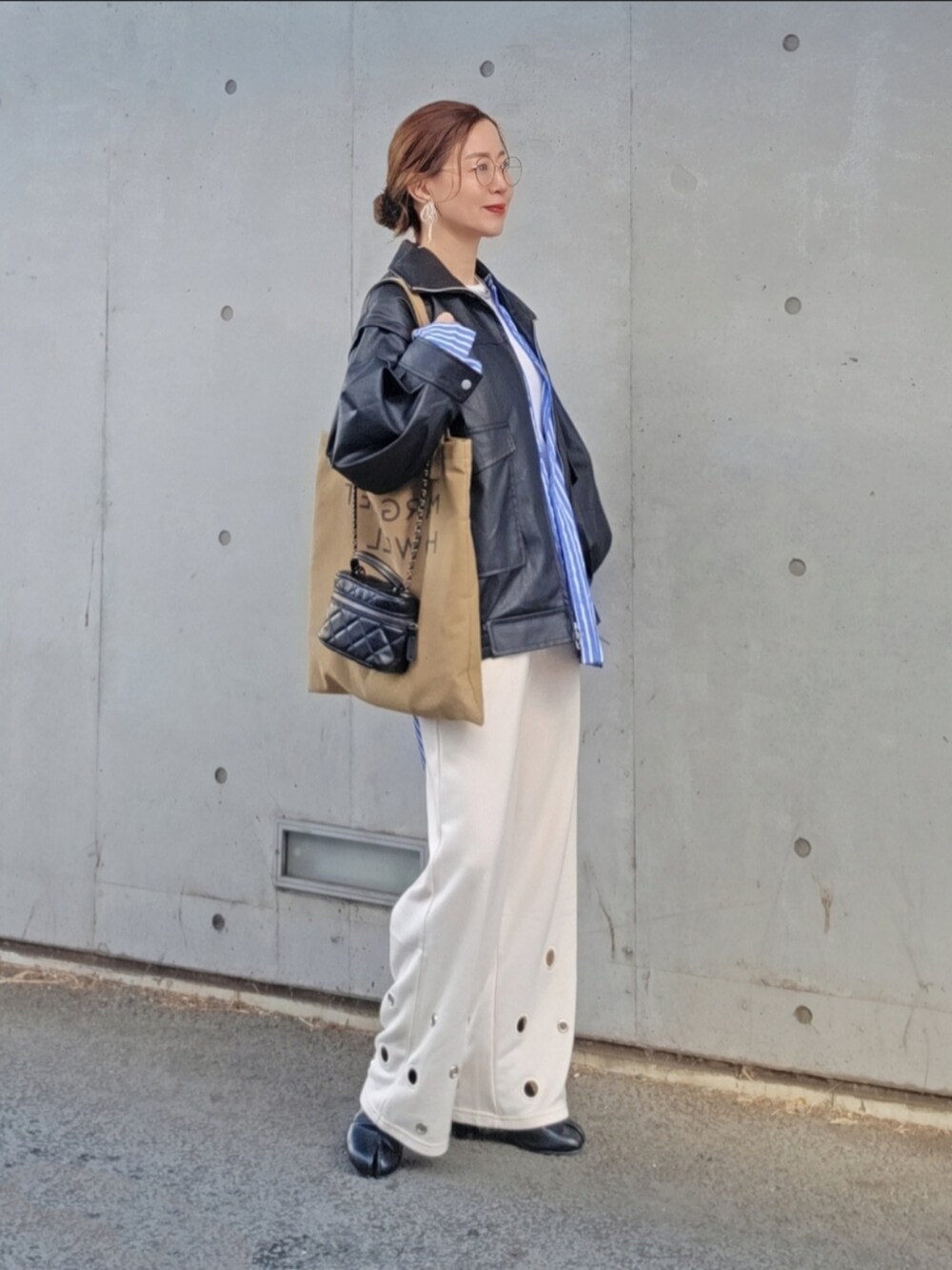 ブラック系のライダースジャケット、ホワイト系のスウェットパンツ、ブルー系のシャツ/ブラウスを着用したレディースの春コーディネートの3枚目の写真