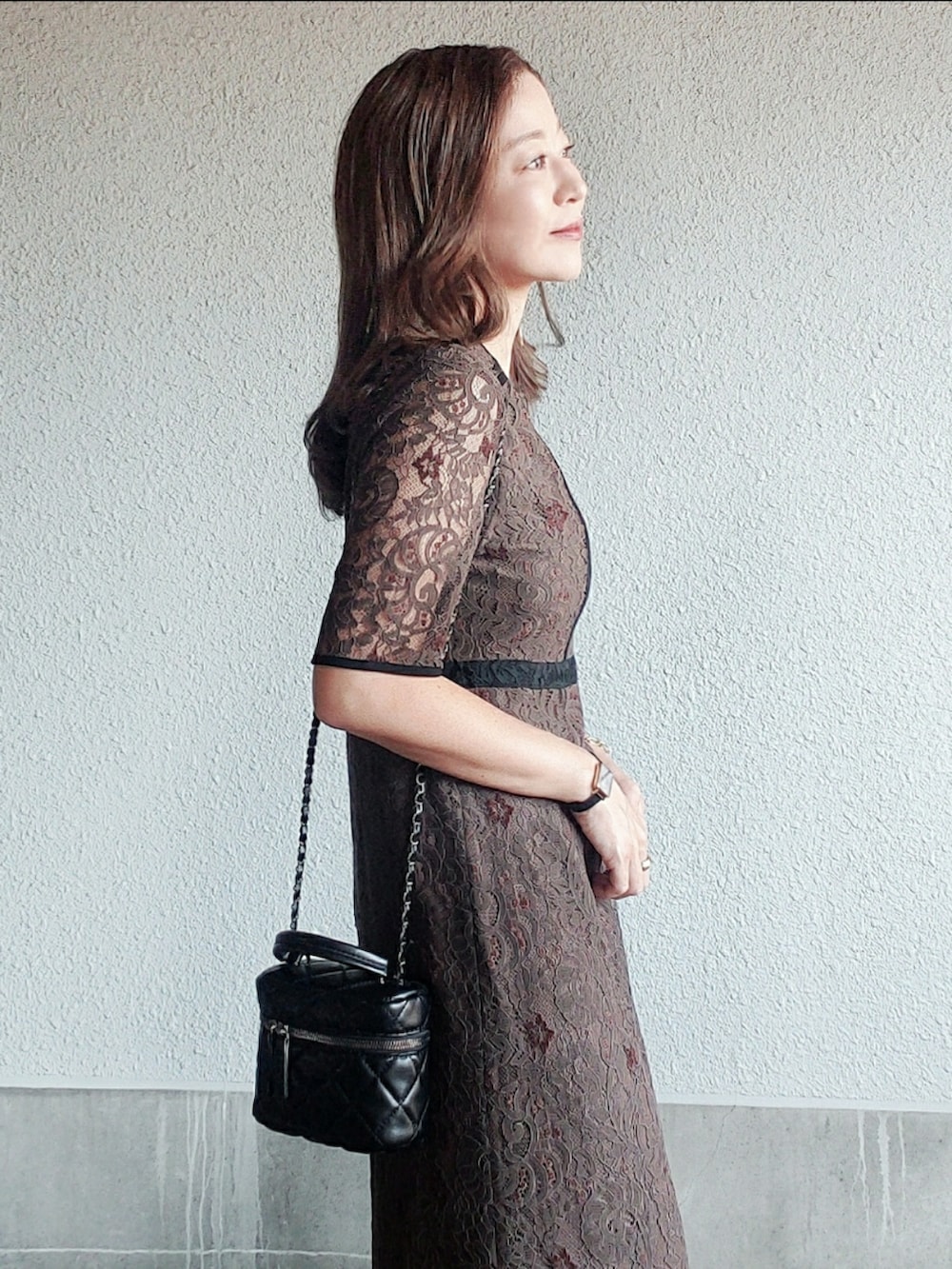 ブラウン系のドレス、ブラック系のブーツ、ブラック系のバッグを着用したレディースの秋コーディネートの3枚目の写真