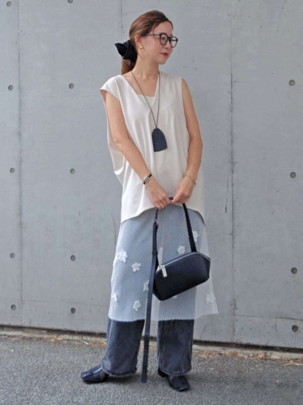 ホワイト系のワンピース、ホワイト系のベスト、ブラック系のショルダーバッグを着用したレディースの秋コーディネートの2枚目の写真