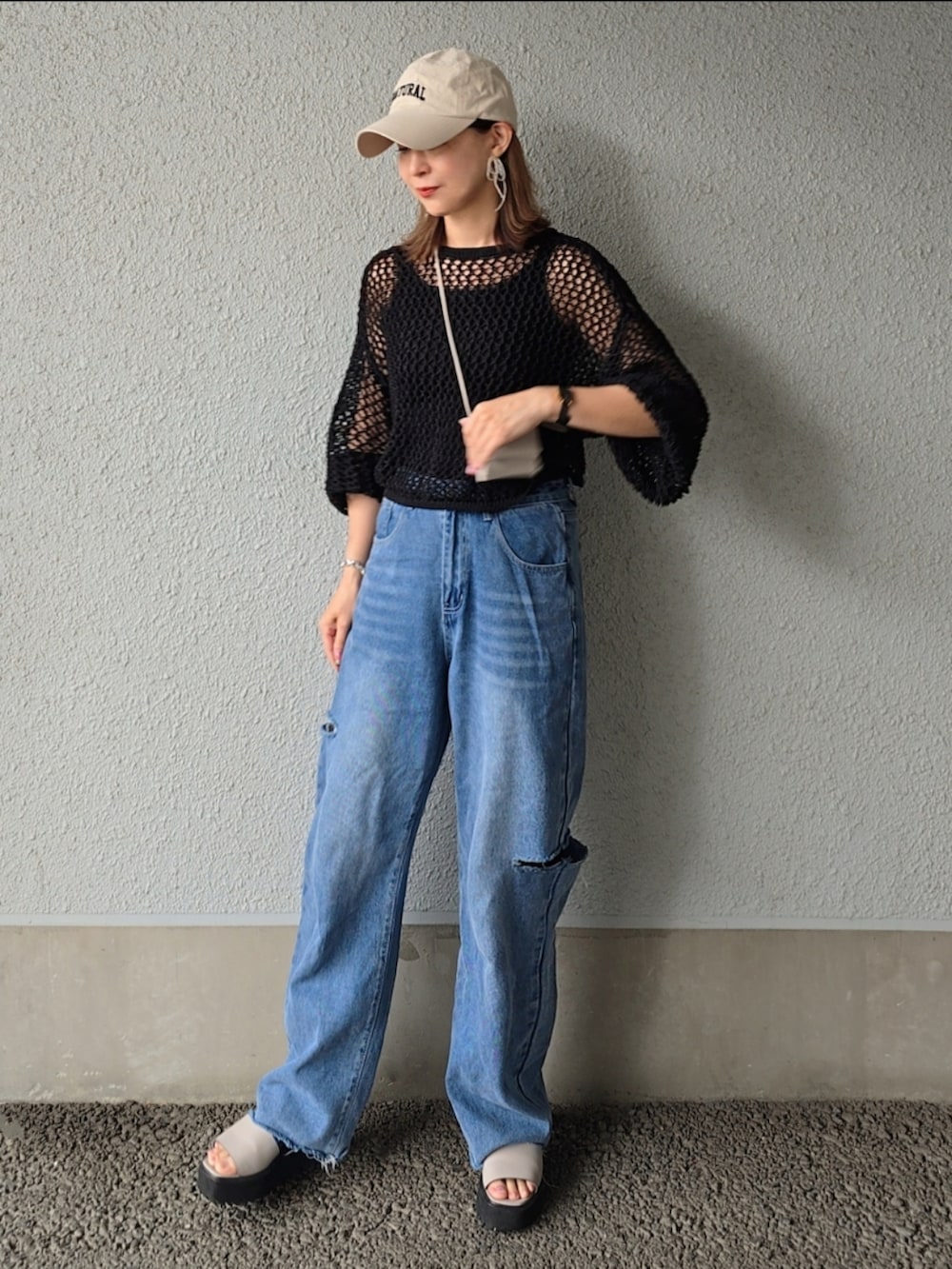 ブラック系のカーディガン/ボレロ、ブルー系のデニムパンツ、グレー系のサンダルを着用したレディースの春コーディネートの3枚目の写真