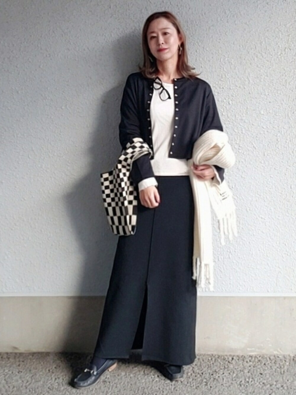 ブラック系のカーディガン/ボレロ、ブラック系のスカート、ブラック系のローファーを着用したレディースの冬コーディネートの2枚目の写真