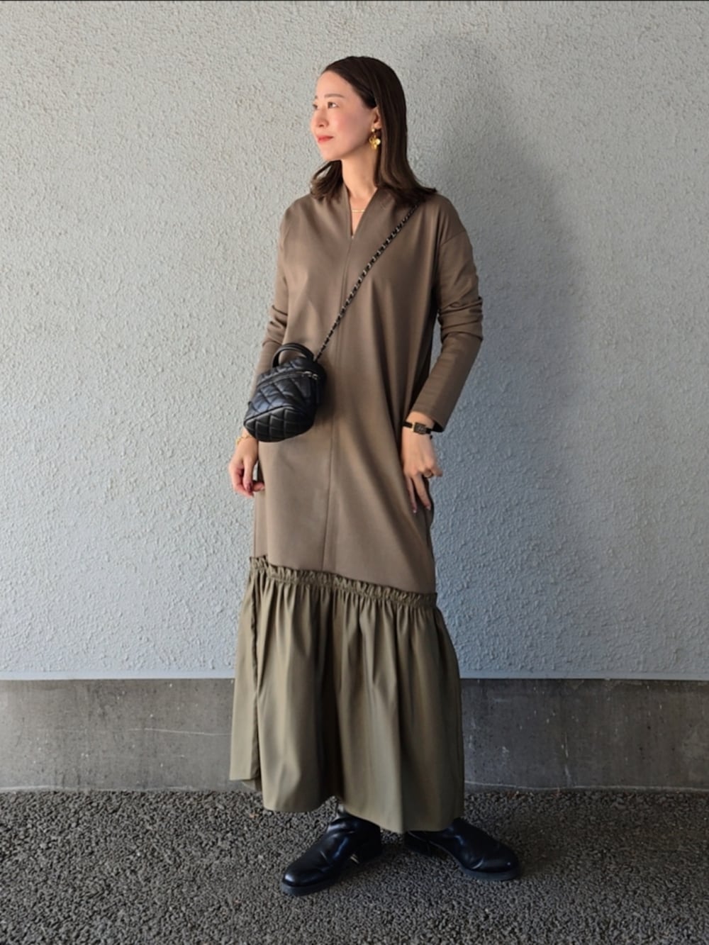 グリーン系のワンピースを着用したレディースの冬コーディネートの2枚目の写真