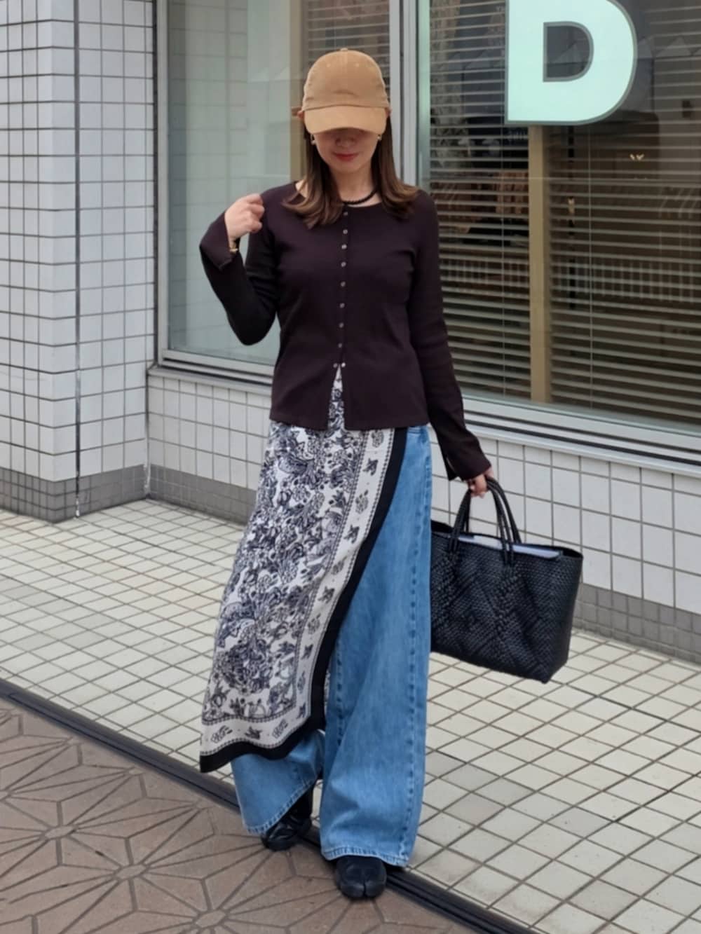 ブラウン系のカーディガン/ボレロ、ブルー系のデニムパンツ、ブラック系のバンダナ/スカーフを着用したレディースの秋コーディネートの2枚目の写真