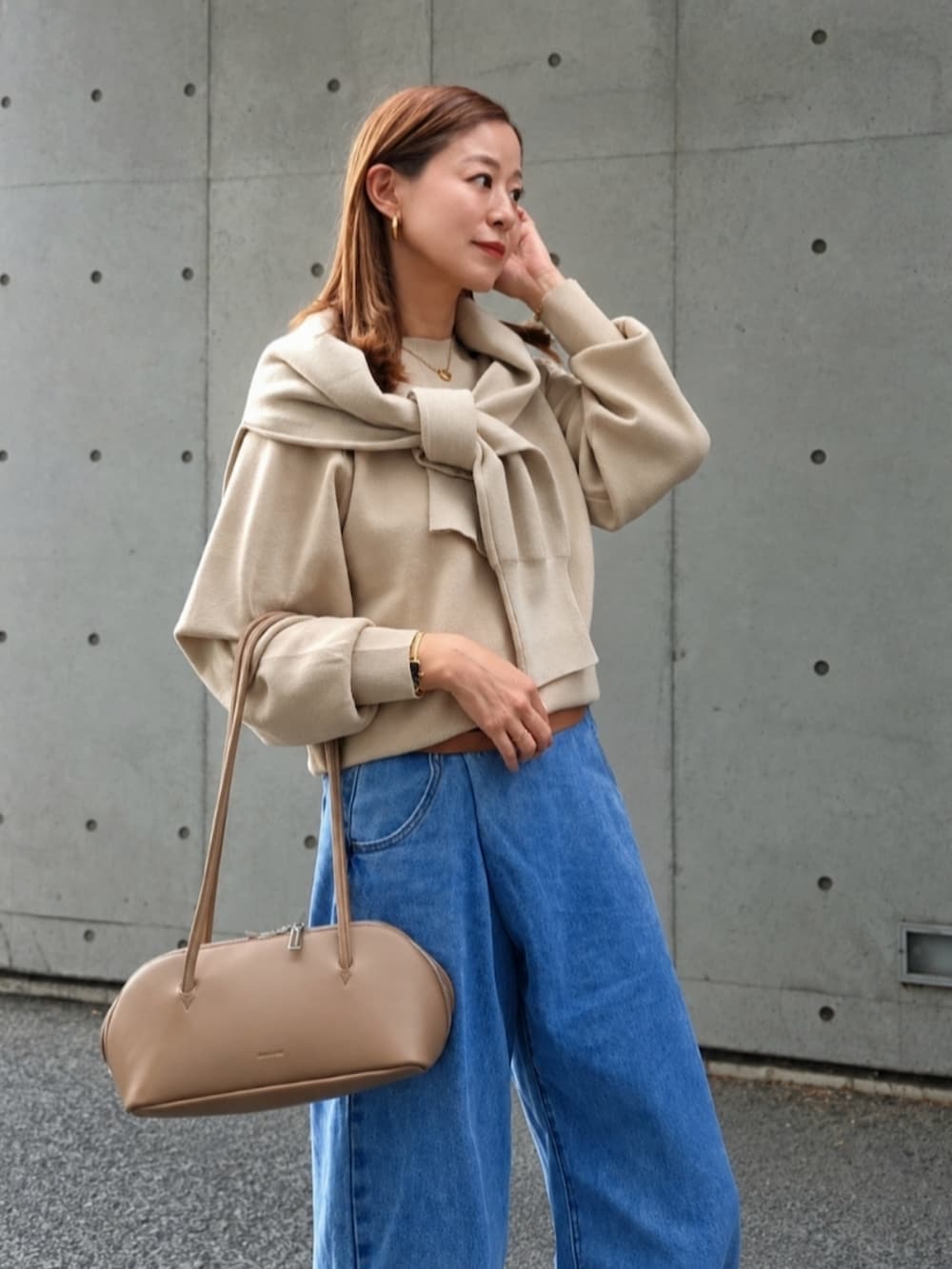 ベージュ系のニット/セーター、イエロー系のブーツ、ブラウン系のショルダーバッグを着用したレディースの秋コーディネートの2枚目の写真