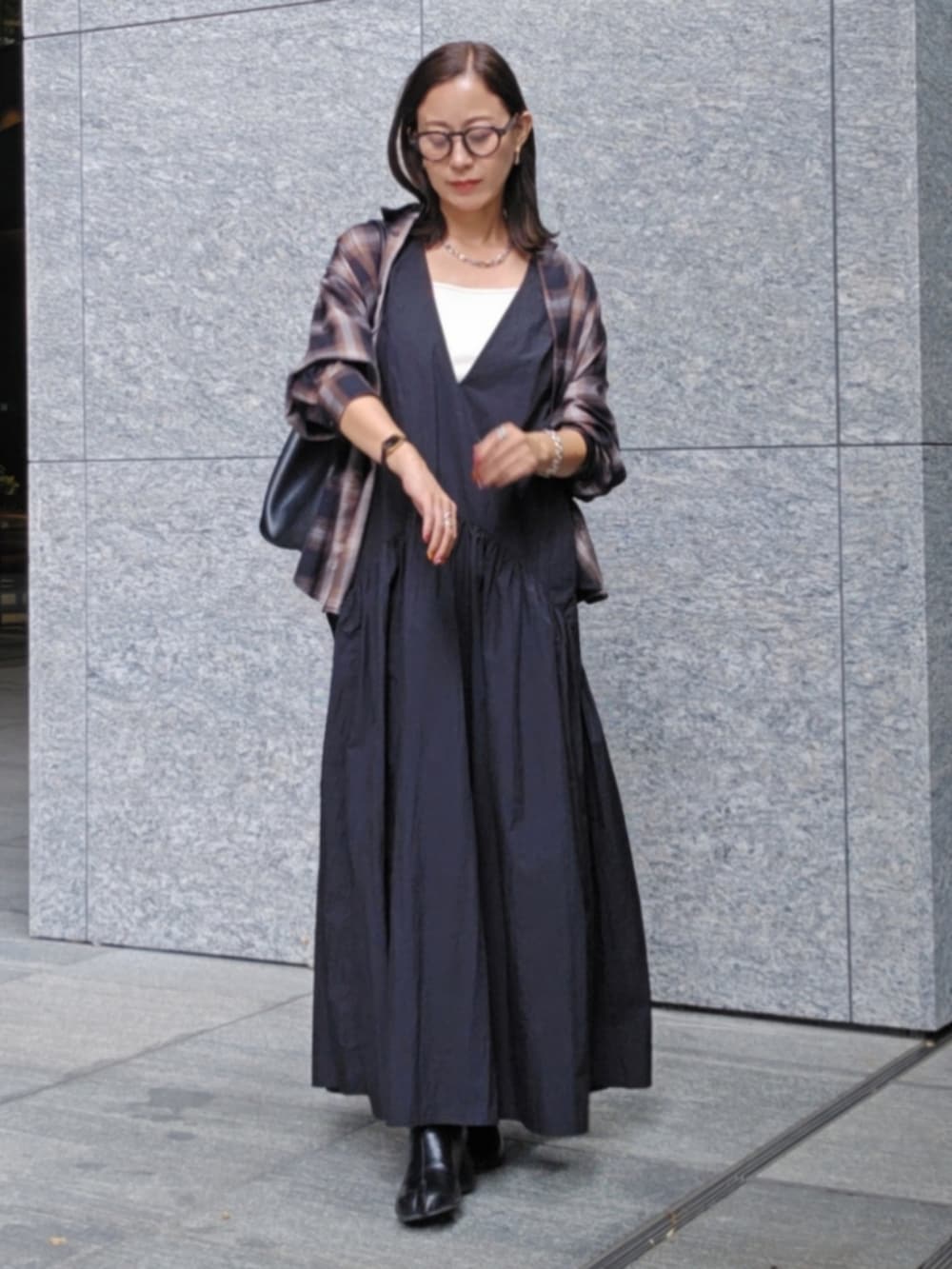 ブラック系のシャツ/ブラウス、ブラック系のワンピース、ブラック系のブーツを着用したレディースの秋コーディネートの2枚目の写真