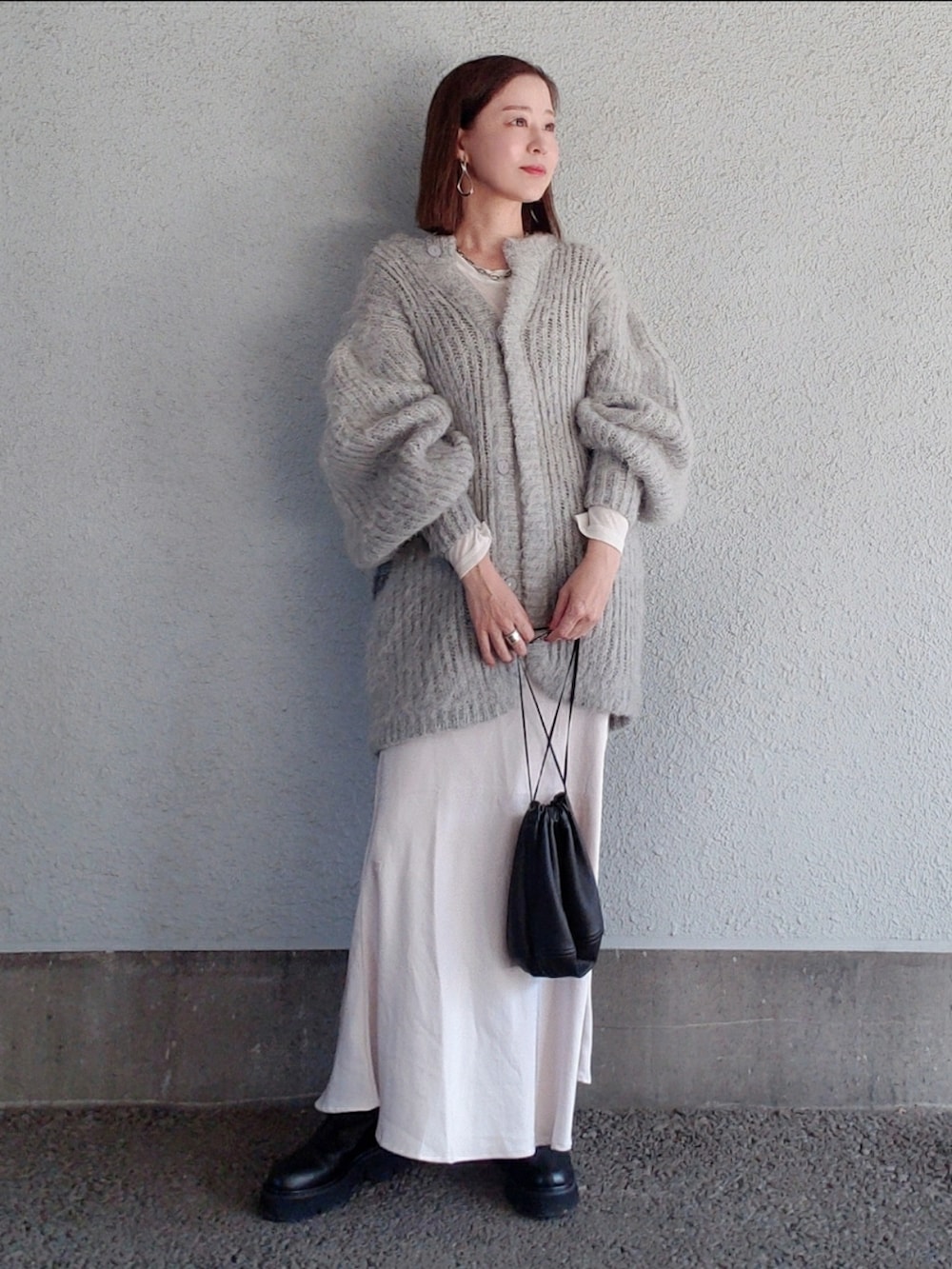 グレー系のカーディガン/ボレロ、ブラック系のバッグ、ベージュ系のスカートを着用したレディースの冬コーディネートの3枚目の写真