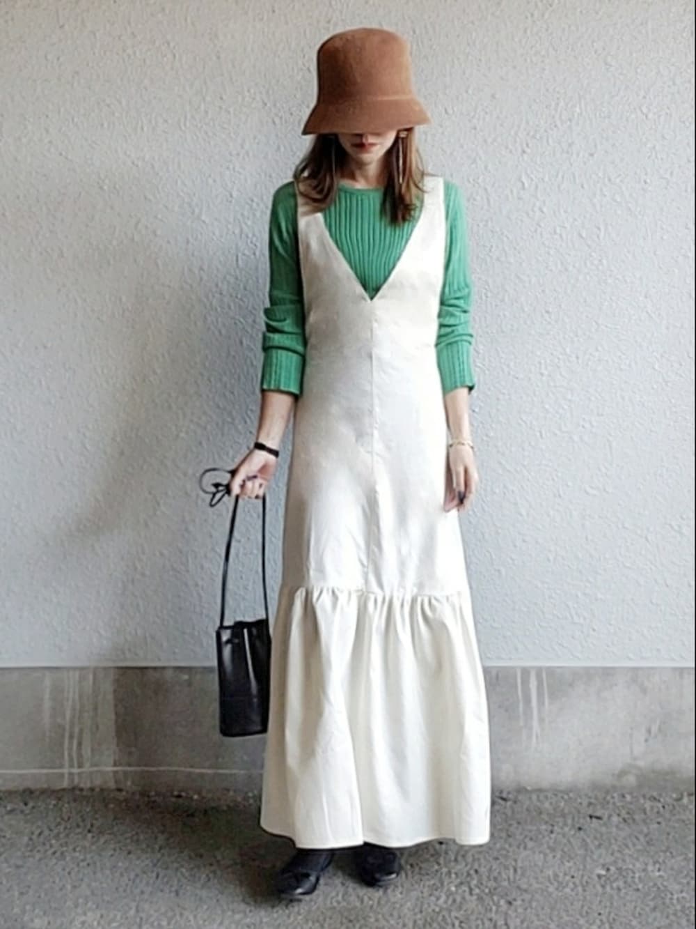 ホワイト系のジャンパースカート、ブラック系のTシャツ/カットソー、ブラック系のサンダルを着用したレディースの春コーディネートの4枚目の写真