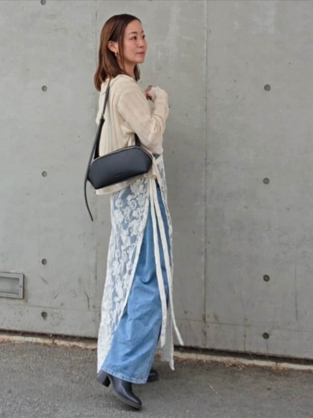 ベージュ系のカーディガン/ボレロ、ホワイト系のスカート、ブルー系のデニムパンツを着用したレディースの春コーディネートの3枚目の写真