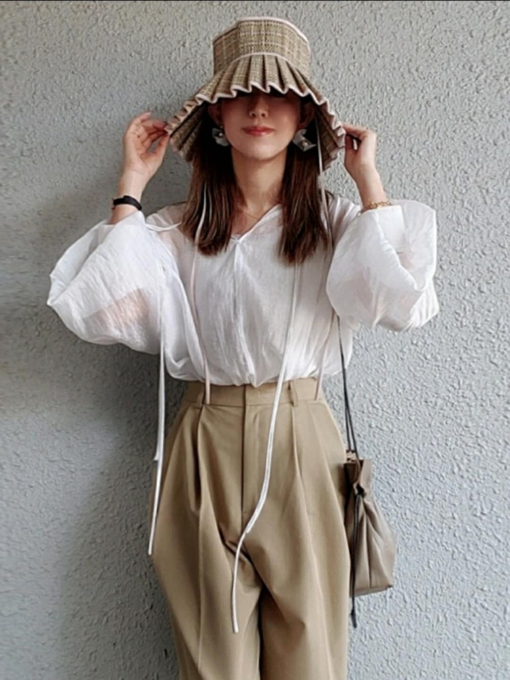 ホワイト系のシャツ/ブラウス、ベージュ系のスラックス、グレー系のサンダルを着用したレディースの春コーディネートの2枚目の写真