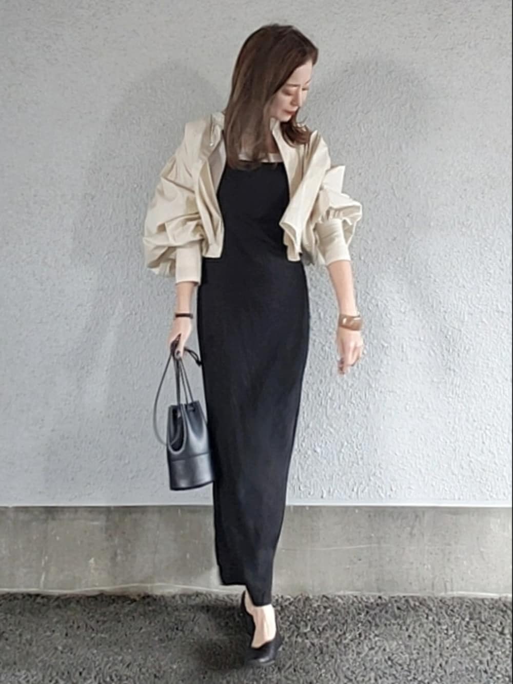ブラック系のワンピース、ブラック系のハンドバッグ、ホワイト系のシャツ/ブラウスを着用したレディースの春コーディネートの2枚目の写真