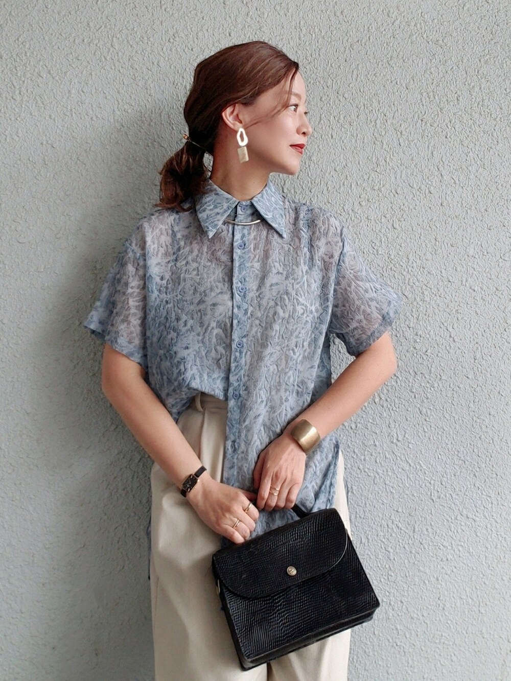 グリーン系のシャツ/ブラウス、ベージュ系のその他パンツ、ブラック系のショルダーバッグを着用したレディースの春コーディネートの2枚目の写真