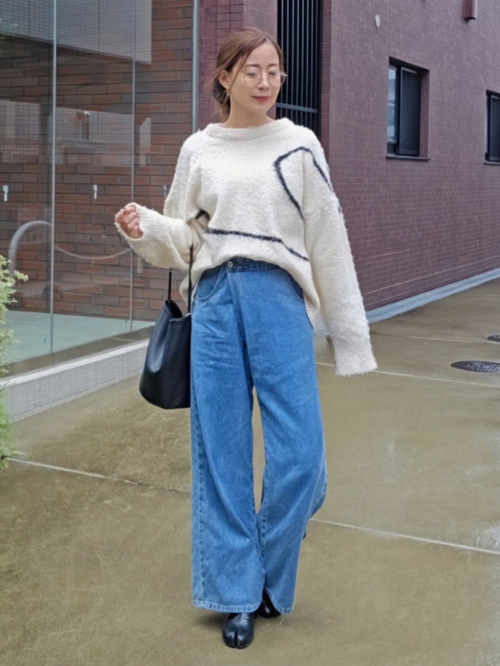 ホワイト系のニット/セーター、ブルー系のデニムパンツ、ブラック系のブーツを着用したレディースの秋コーディネートの3枚目の写真