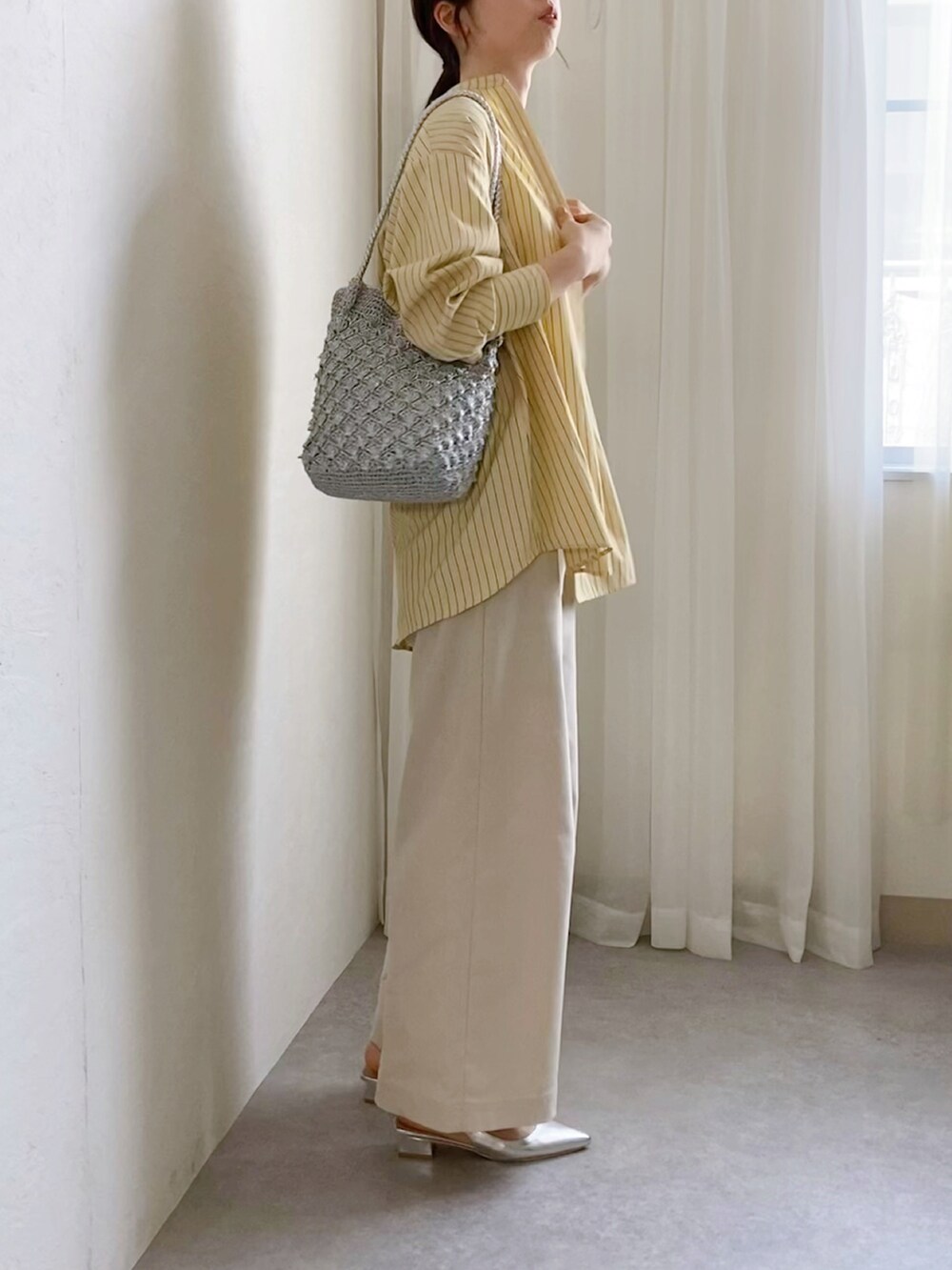 イエロー系のシャツ/ブラウス、ホワイト系のタンクトップ、シルバー系のトートバッグを着用したレディースの春コーディネートの2枚目の写真