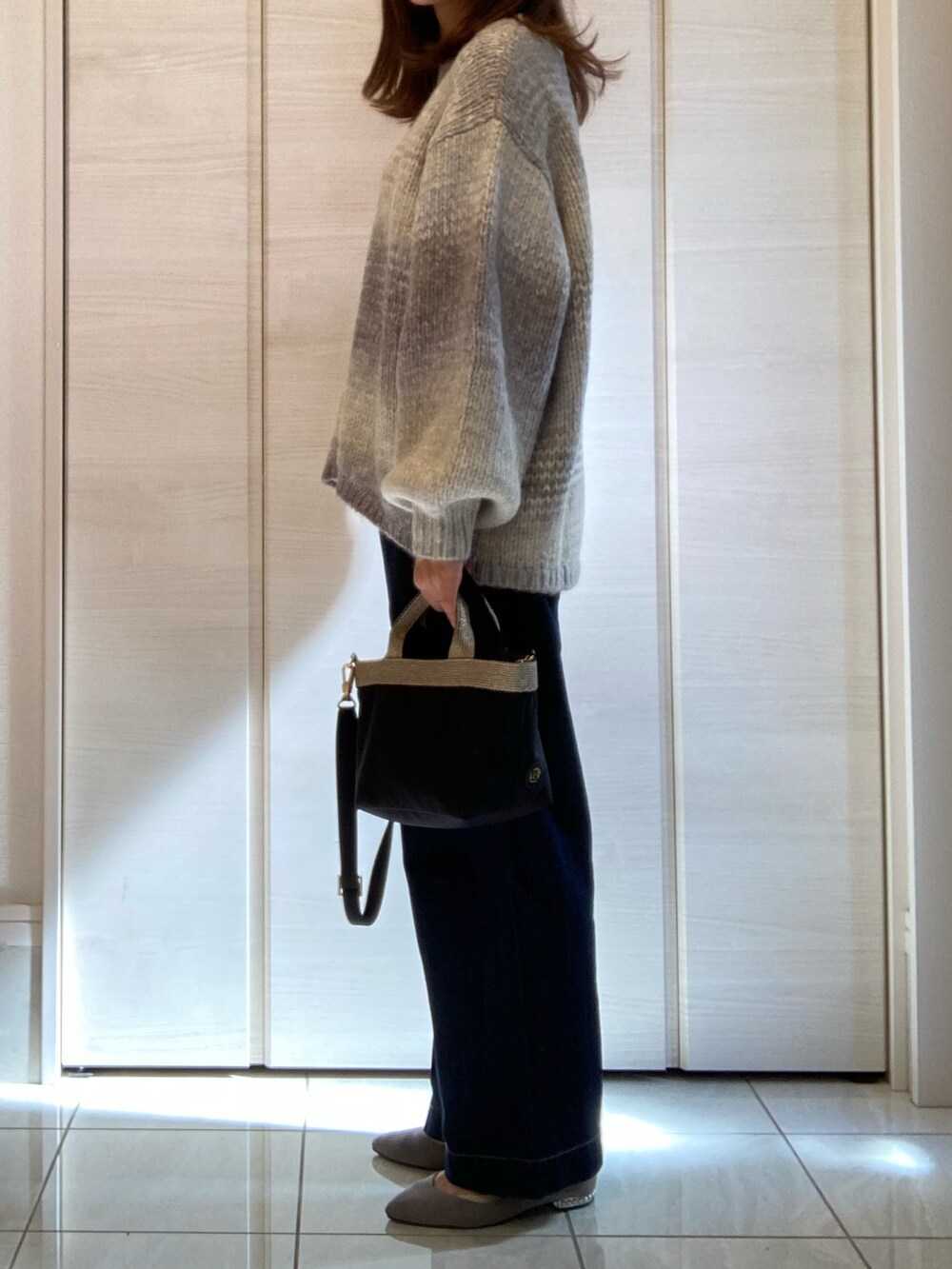 グレー系のニット/セーター、その他のパンツ、ブラック系のショルダーバッグを着用したレディースの秋コーディネートの2枚目の写真