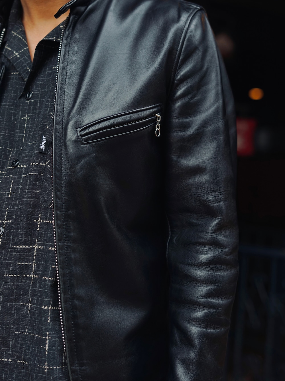 ブラック系のライダースジャケット、ブラック系のシャツ/ブラウス、ブラック系のチノパンツを着用したメンズの春コーディネートの4枚目の写真