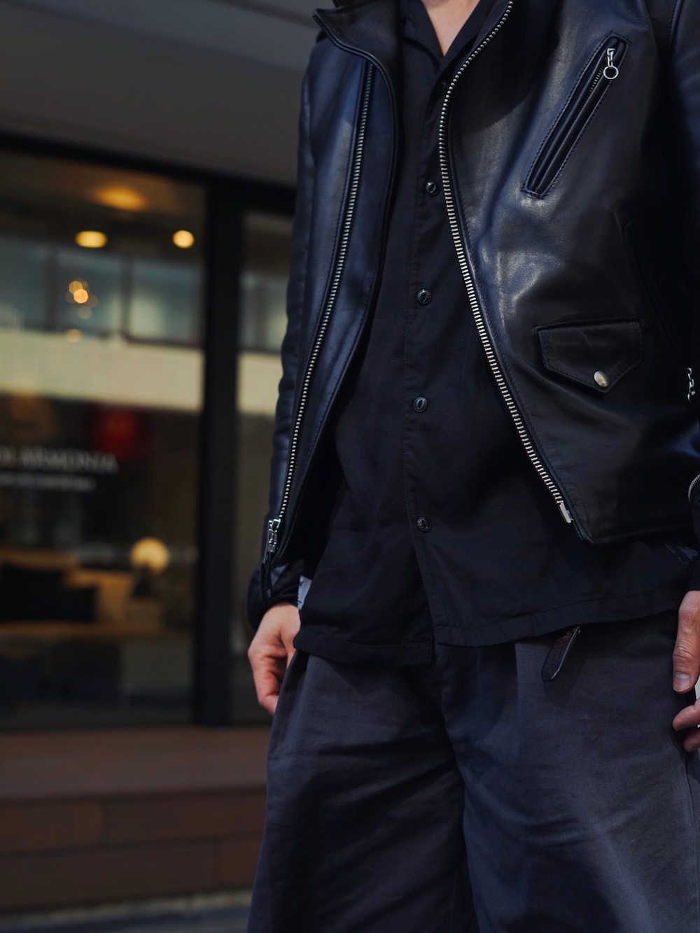 ブラック系のライダースジャケット、ブラック系のシャツ/ブラウス、ブラック系のチノパンツを着用したメンズの春コーディネートの3枚目の写真