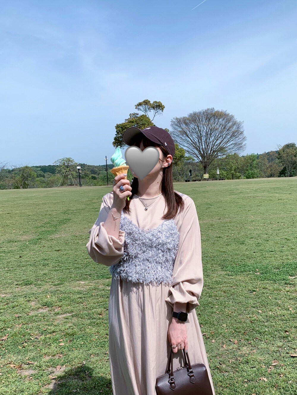 グレー系のキャミソール、ブラウン系のボストンバッグ、ブラウン系のキャップを着用したレディースの春コーディネートの2枚目の写真