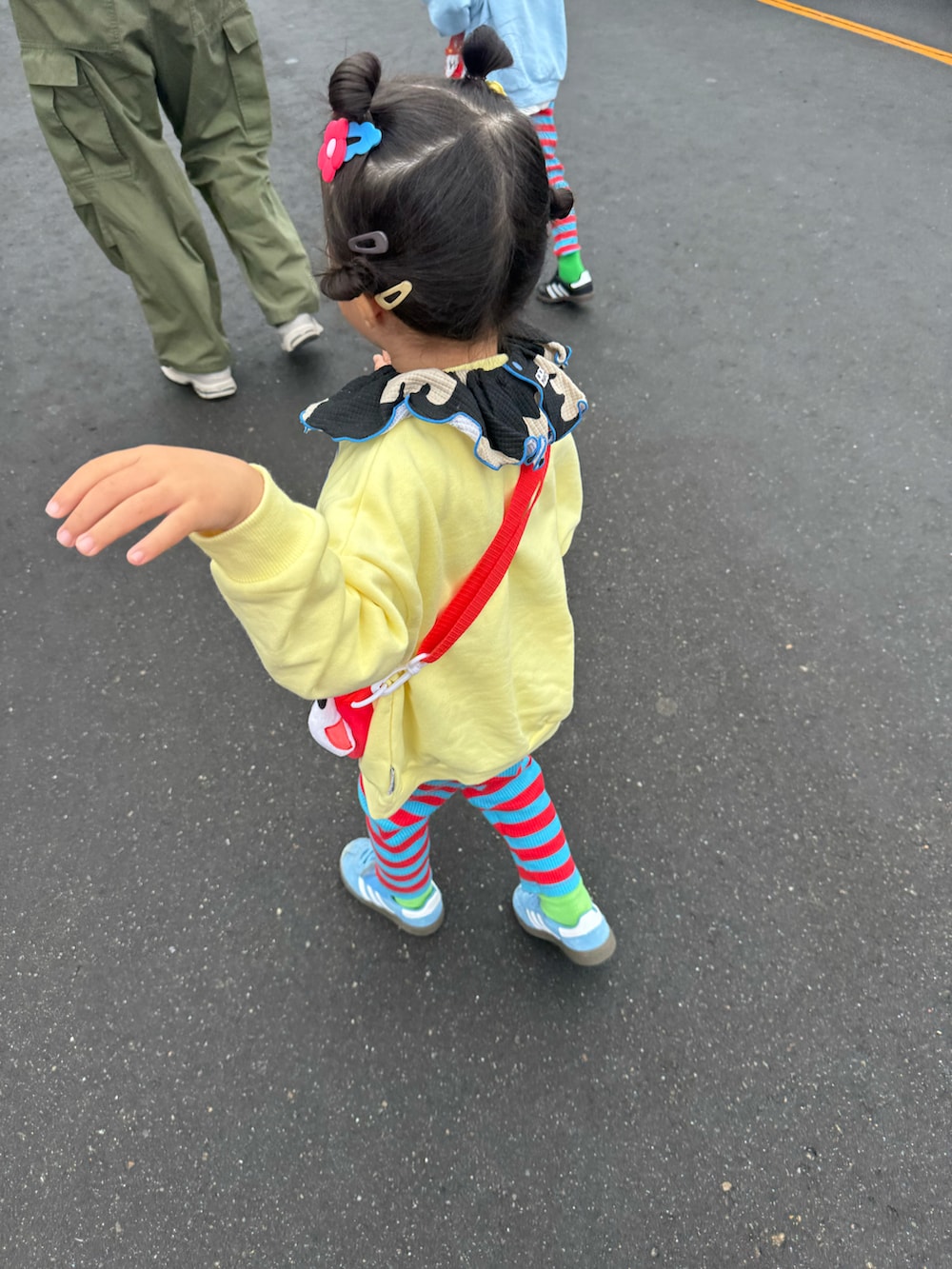 イエロー系のスウェット、レッド系のスウェット、ブルー系のスニーカーを着用したキッズの秋コーディネートの4枚目の写真