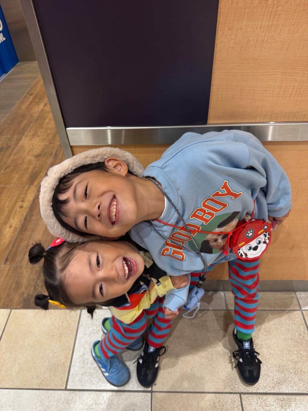 ブルー系のスウェット、ブラック系のスニーカー、ベージュ系のキャップを着用したキッズの秋コーディネートの3枚目の写真