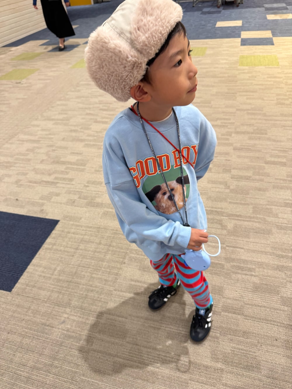 ブルー系のスウェット、ブラック系のスニーカー、ベージュ系のキャップを着用したキッズの秋コーディネートの2枚目の写真