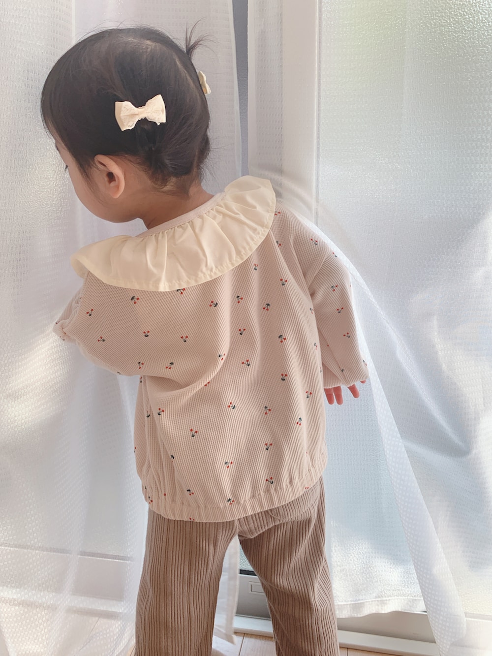 ベージュ系のカーディガン/ボレロを着用したキッズの秋コーディネートの2枚目の写真