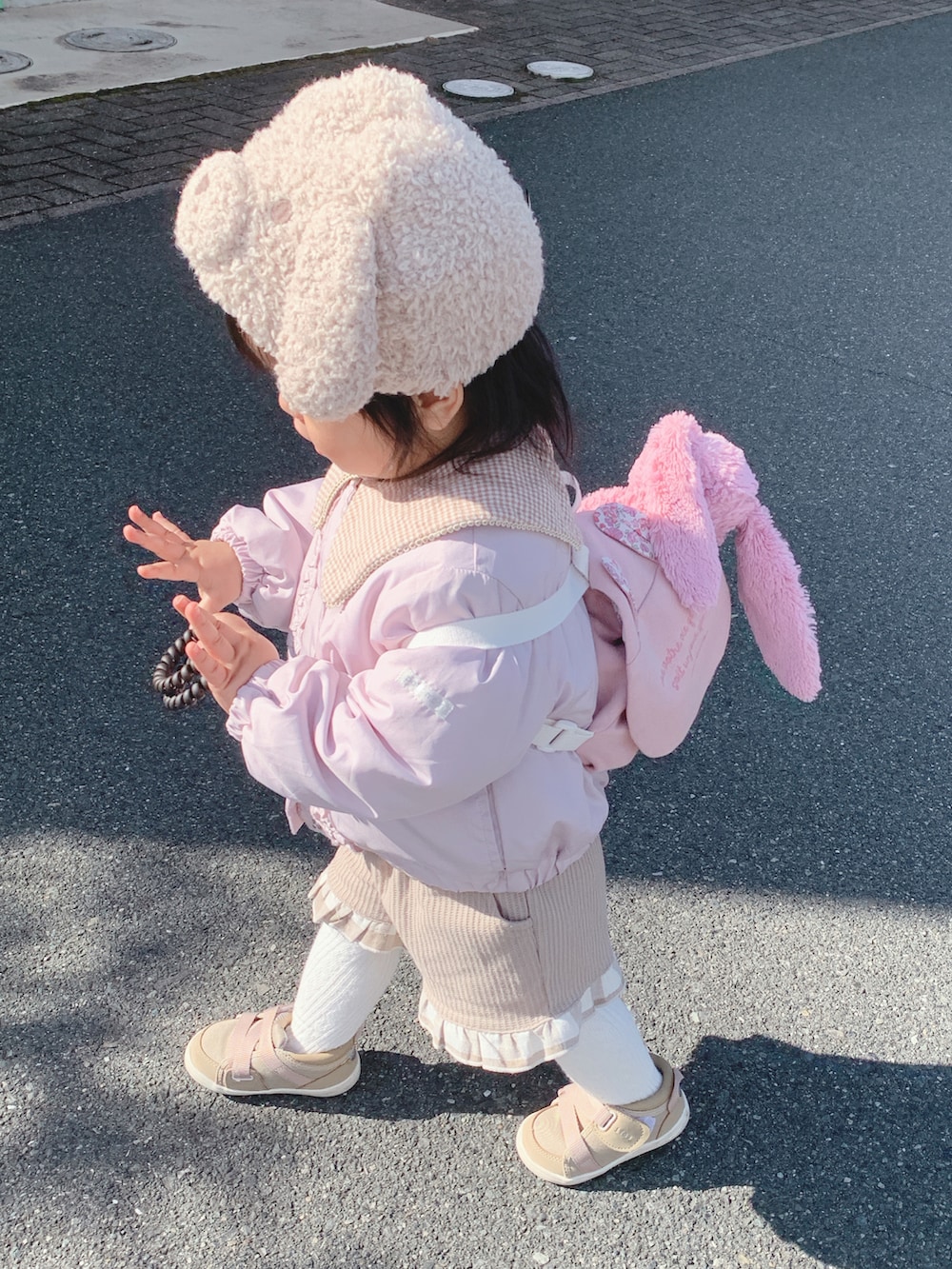 ベージュ系のスニーカー、ピンク系のジャケット/アウター、ベージュ系のその他ベビー用品を着用したキッズの冬コーディネートの2枚目の写真