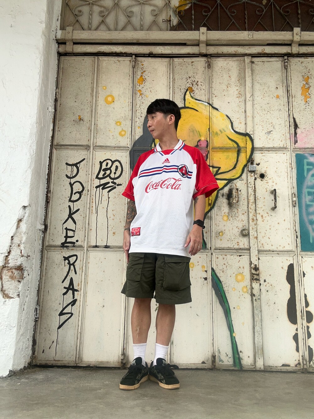 ホワイト系のジャージ、グリーン系のカーゴパンツ、ブラック系のスニーカーを着用したメンズの冬コーディネートの2枚目の写真