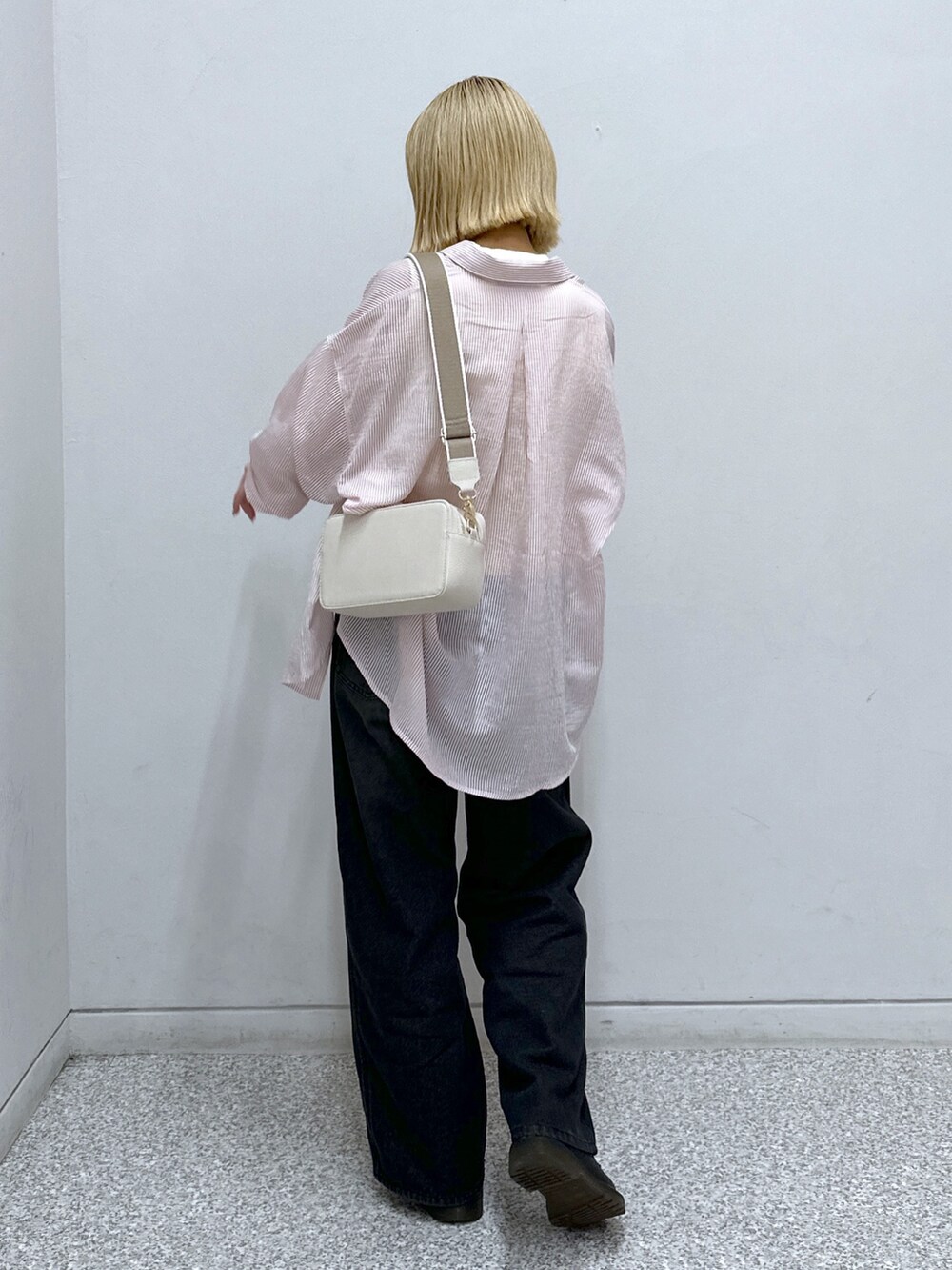 ピンク系のシャツ/ブラウス、ホワイト系のニット/セーター、ブラック系のデニムパンツを着用したレディースの夏コーディネートの3枚目の写真