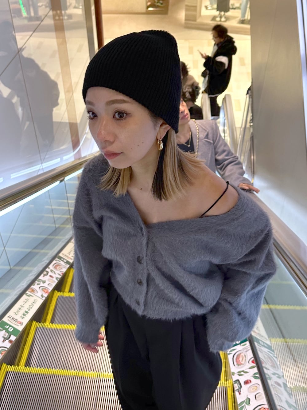 グレー系のカーディガン/ボレロ、ホワイト系のニット/セーター、ブラック系のスラックスを着用したレディースの冬コーディネートの4枚目の写真