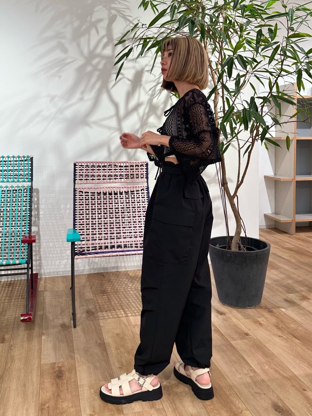 ブラック系のカーディガン/ボレロ、ブラック系のカーゴパンツ、ホワイト系のサンダルを着用したレディースの夏コーディネートの3枚目の写真