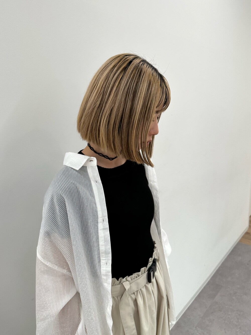 ブラック系のニット/セーター、ホワイト系のシャツ/ブラウス、ベージュ系のカーゴパンツを着用したレディースの夏コーディネートの5枚目の写真