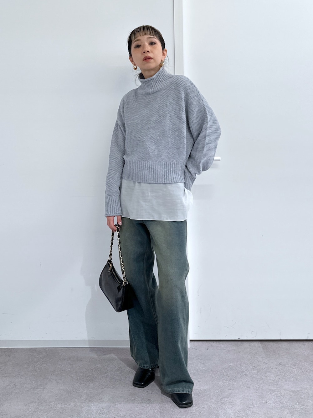 ブラウン系のチェスターコート、ホワイト系のTシャツ/カットソー、グレー系のニット/セーターを着用したレディースの冬コーディネートの5枚目の写真